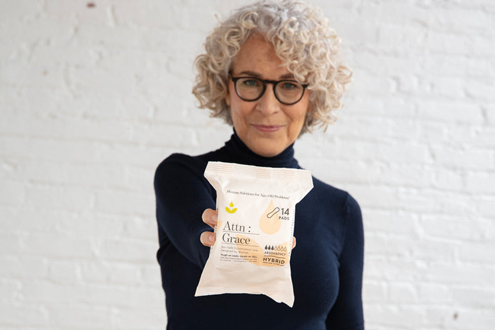 Woman holding a pack of bladder leak pads