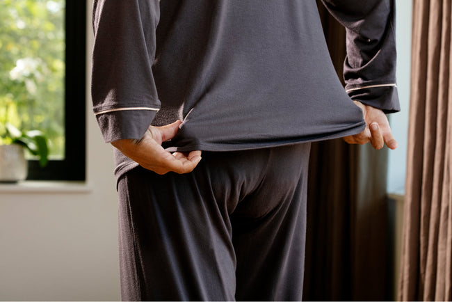 older woman in pajamas with her back toward the camera