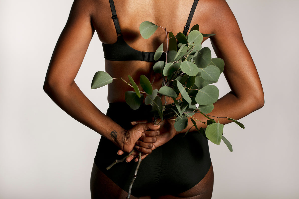 woman holding plant behind her back