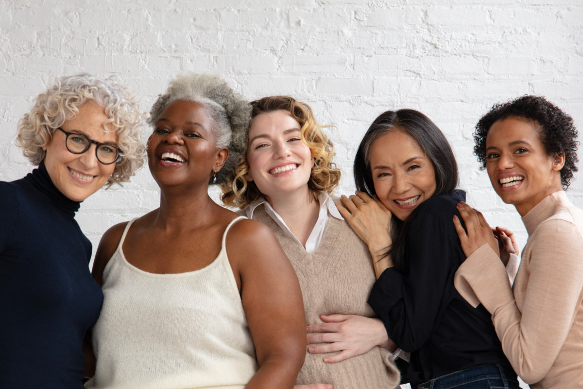 group of women of all ages standing together smiling