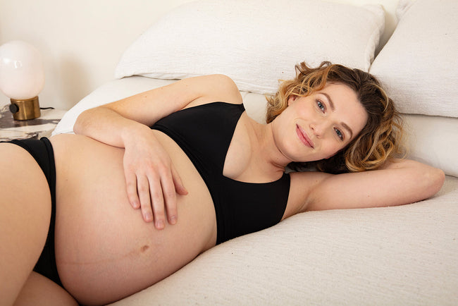 woman wearing athletic leggings and an athletic top, her backing facing us
