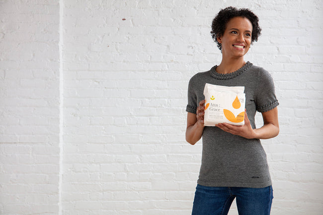 woman holding pack of Attn: Grace incontinence pads