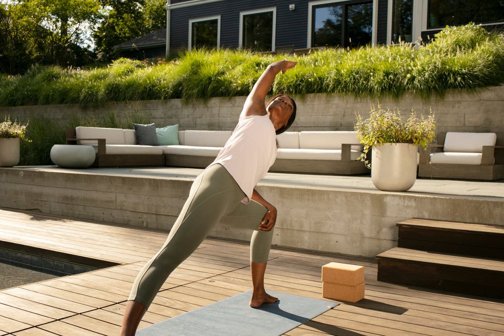 woman in athletic clothes doing yoga outside