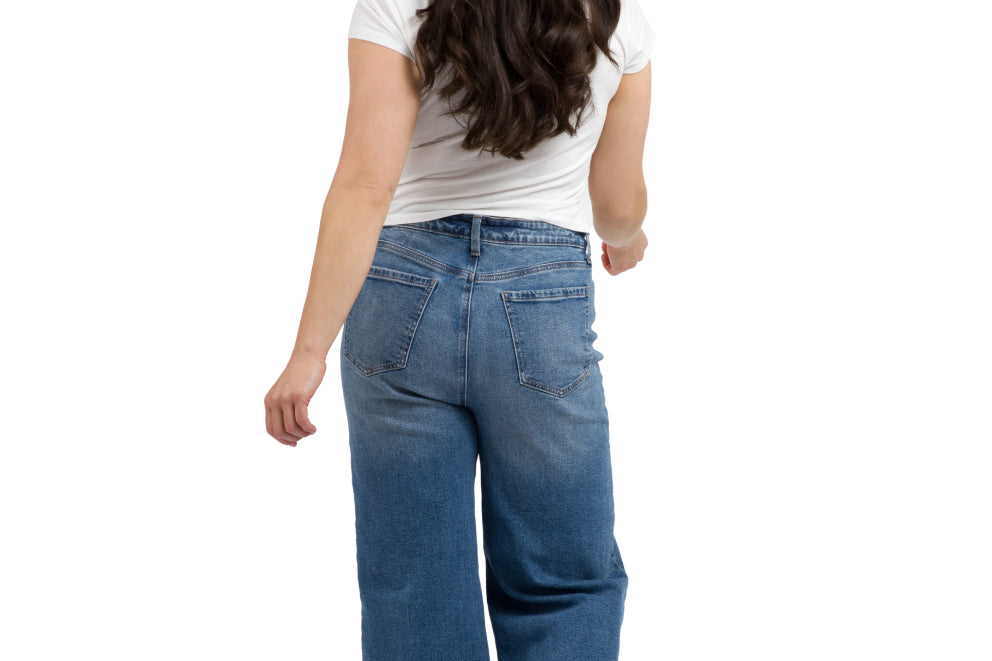 Woman standing with her back to the camera wearing jeans and a white t shirt