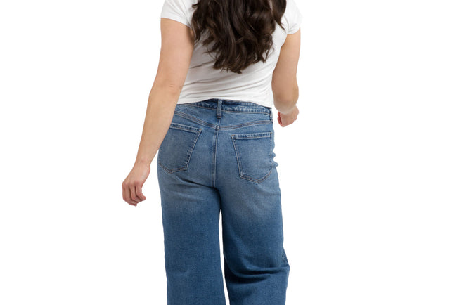 Woman standing with her back to the camera wearing jeans and a white t shirt