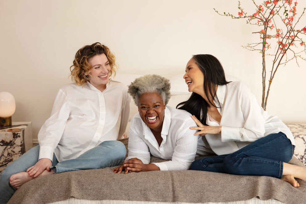 Three women on a bed laughing